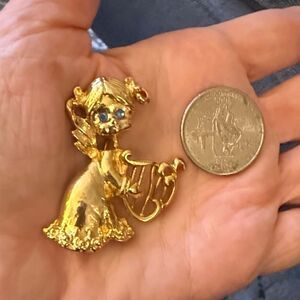 Gerry’s Vintage Gold Tone Brooch Featuring Angel With Blue Eyes Playing Harp.